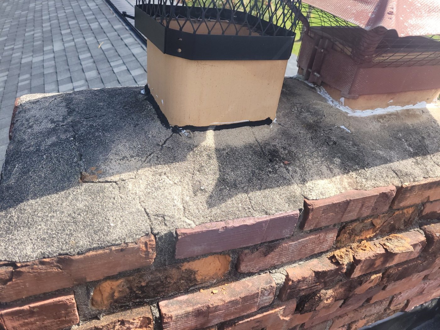 Damaged chimney crown and brick requiring repair